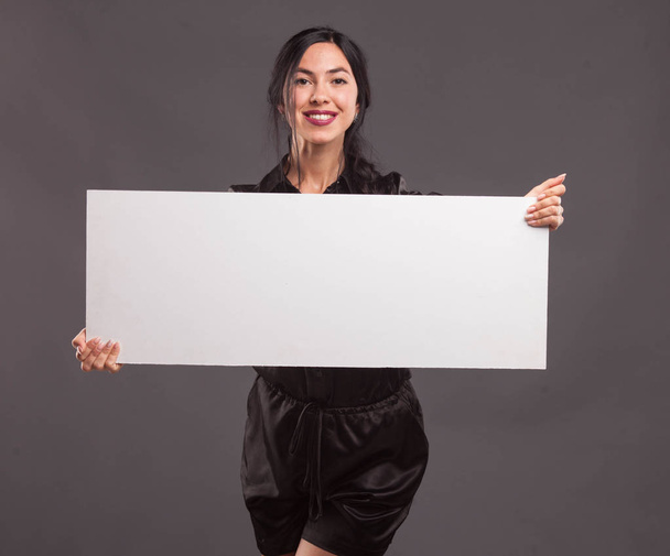 Young confident woman showing presentation, pointing on placard - Φωτογραφία, εικόνα
