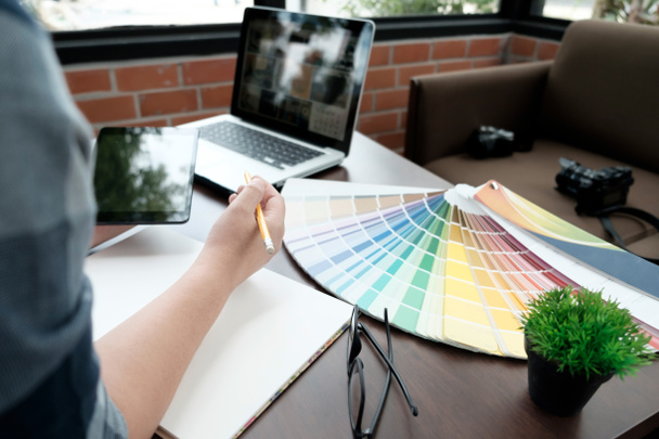 Graafinen suunnittelu ja väri pyyhkäisynäytteet ja kynät pöydälle. Arkkitehti
 - Valokuva, kuva