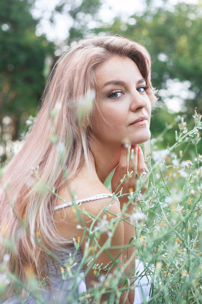 Portrait of a young beautiful woman in a flower meadow. - Photo, Image