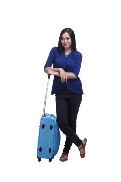 Young asian woman traveler posing beside a suitcase - 写真・画像