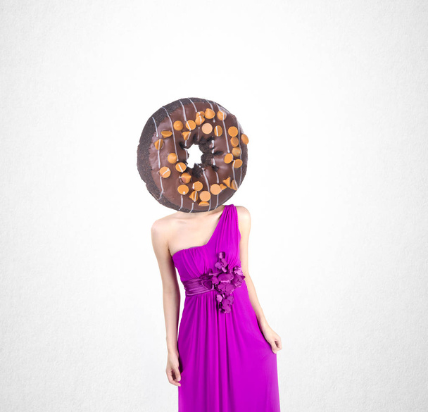 Woman and donut with concept on a background. - Foto, afbeelding