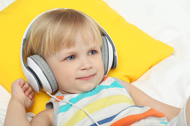 Little boy with headphones in bed - Foto, Imagen