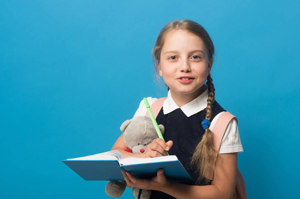 Girl with braids and happy face. Kid in school uniform - Zdjęcie, obraz