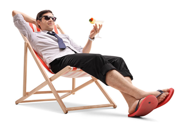 Businessman with a cocktail relaxing in a deck chair - Fotó, kép