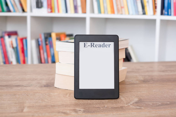 Lector de libros electrónicos en una pila de libros
 - Foto, Imagen