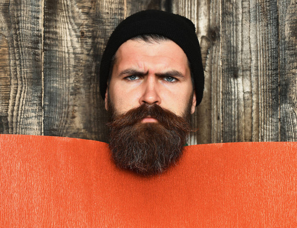 Bearded brutal caucasian hipster with red paper sheet - Фото, зображення