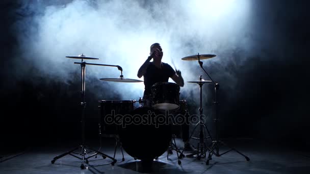 Energetic musician plays good music on drums. Black smoky background. Silhouette - Metraje, vídeo