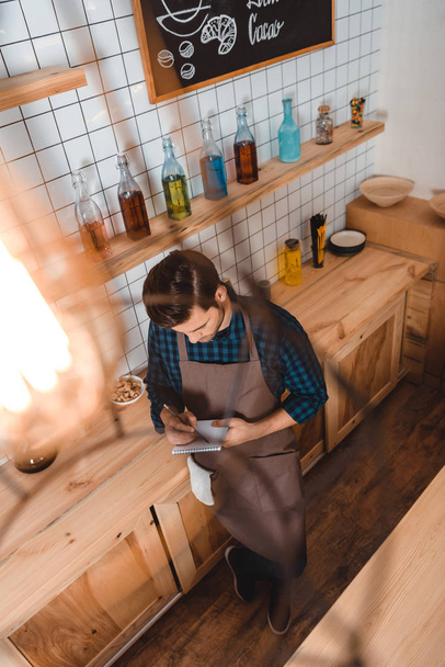 barista making notes in notebook - Photo, Image
