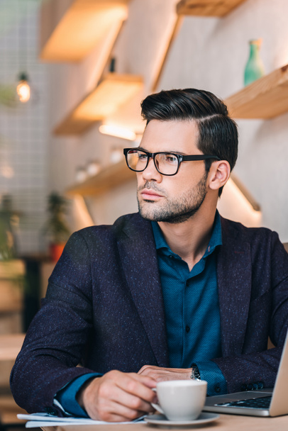 pensive businessman with laptop in cafe - Foto, Imagen