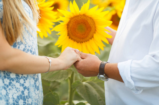 Couple in love in the field of romantic sunflowers - Фото, изображение