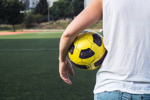 Vrouw met een voetbal op het veld - Foto, afbeelding