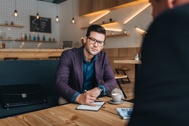 бизнесмены, имеющие встречу в кафе
 - Фото, изображение