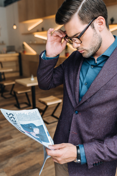 businessman reading newspaper in cafe - Foto, imagen