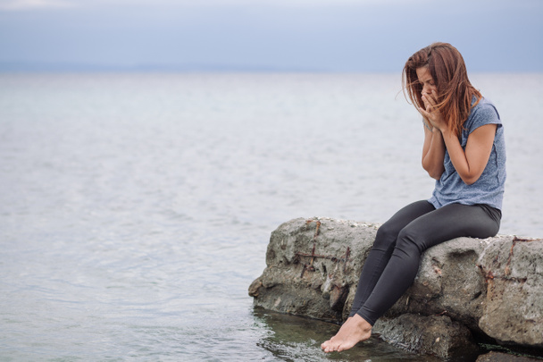 Vrouw alleen en depressief aan zee - Foto, afbeelding
