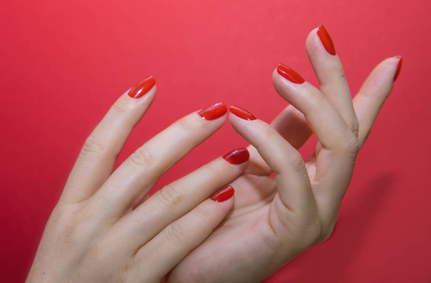 Beautiful female hands with red manicure and nail isolated - Фото, зображення