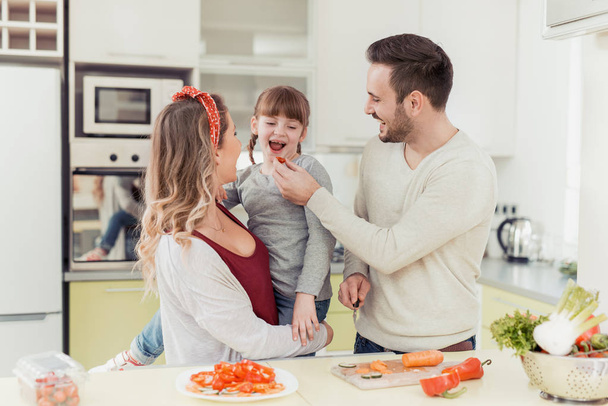 Щаслива сім'я за кухонним столом
 - Фото, зображення