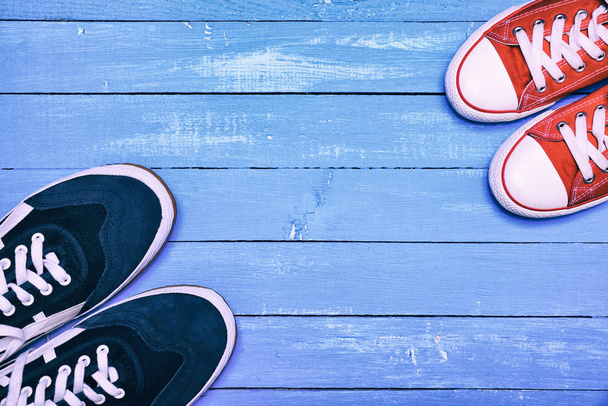 Δύο ζευγάρια αθλητικά παπούτσια, πάνινα παπούτσια μπλε άντρες και γυν κόκκινο - Φωτογραφία, εικόνα