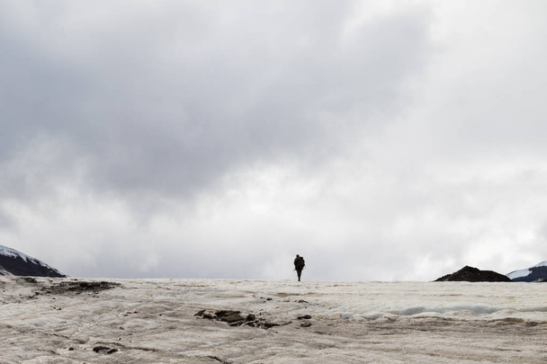 Ο άνθρωπος που το περπάτημα μακριά σε απόσταση σε έναν παγετώνα - Φωτογραφία, εικόνα