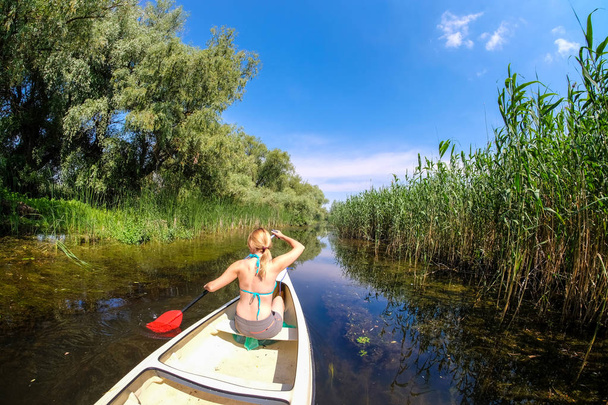Femme naviguant dans les canaux du delta du Danube en bateau
 - Photo, image
