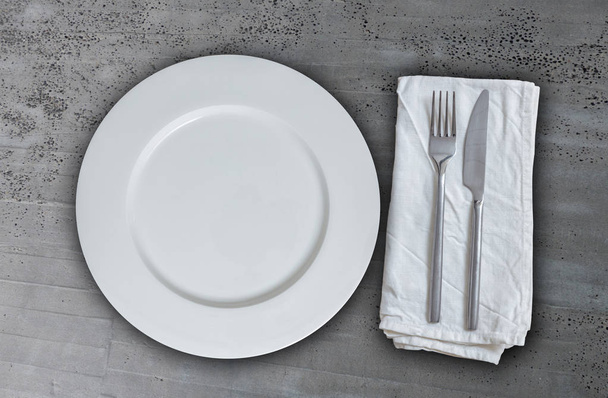 Empty plate with cutlery on concrete background - Zdjęcie, obraz