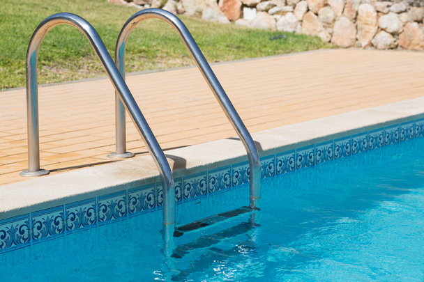 Stainless steel steps leading into swimming pool - Photo, Image