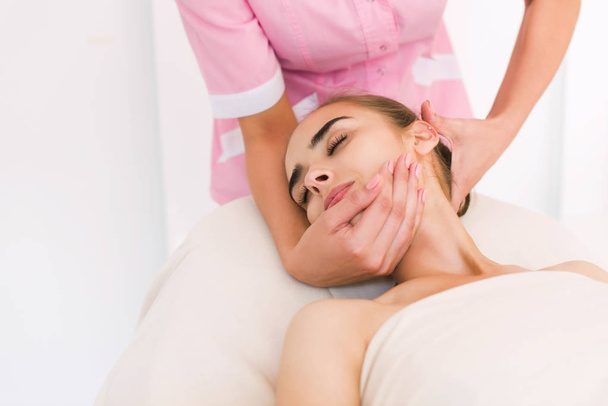 Esteticista haciendo masaje de rostros femeninos
. - Foto, Imagen