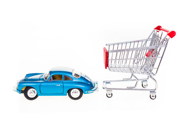 Car pulling shopping cart conceptual image isolated on white bac - Фото, изображение