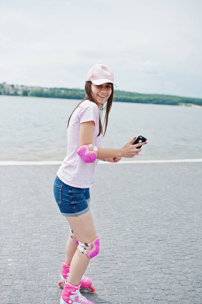 Portrait of a fantastic young woman roller skating with her phon - Photo, image