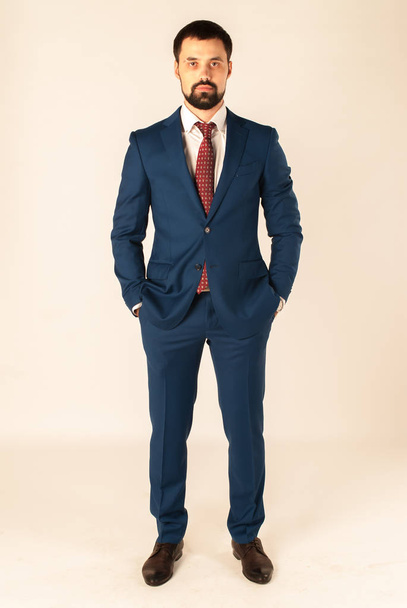 Elegancia y estilo. Retrato de un joven guapo con esmoquin y corbata roja
. - Foto, Imagen