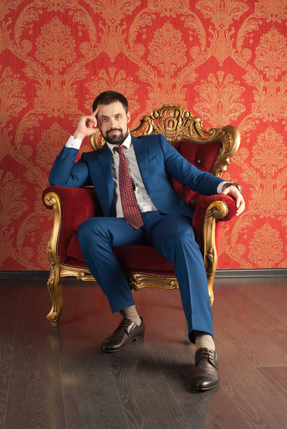 Elegance a styl. Portrét pohledný mladý muž na sobě smoking a červená kravata. - Fotografie, Obrázek