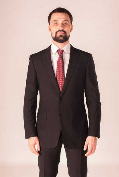 Élégance et style. Portrait de beau jeune homme portant smoking et cravate rouge
. - Photo, image