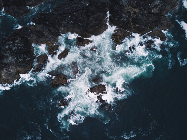 Lanzamiento aéreo de olas golpeando rocas
 - Foto, imagen
