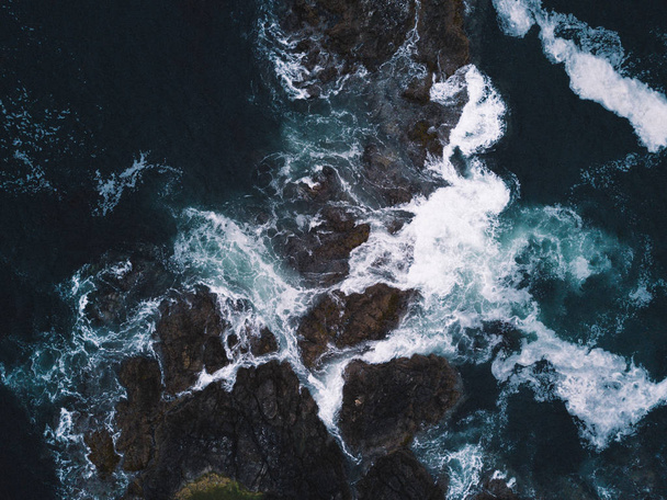 Aerial shot of waves hitting rocks - Photo, Image