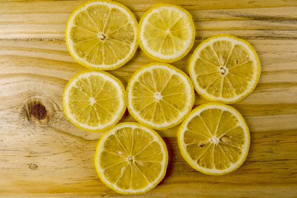 Fresh lemon slices on the wooden background. - Zdjęcie, obraz