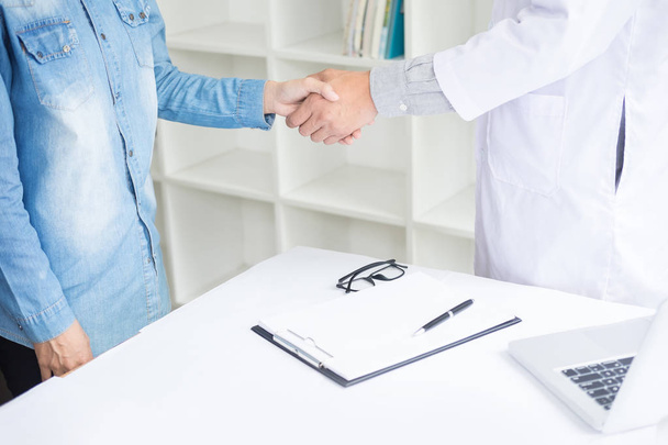 Doctor shakes hands at medical office with patient - Photo, Image