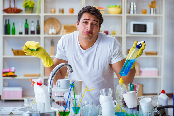 Bulaşıkları yıkamaktan bıkmış bir adam. - Fotoğraf, Görsel