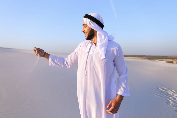 Портрет мусульманина в песчаной пустыне ясным летним днем
 - Фото, изображение
