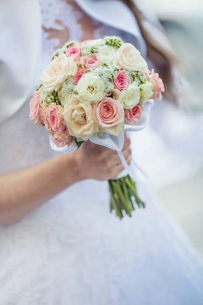 Wedding bouquet. Bride holding her wedding bouquet with roses - Photo, Image