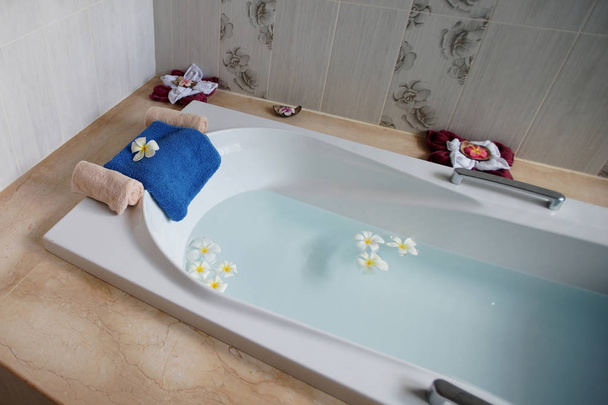 top view of bathtub with towel and frangipani flower - Fotoğraf, Görsel