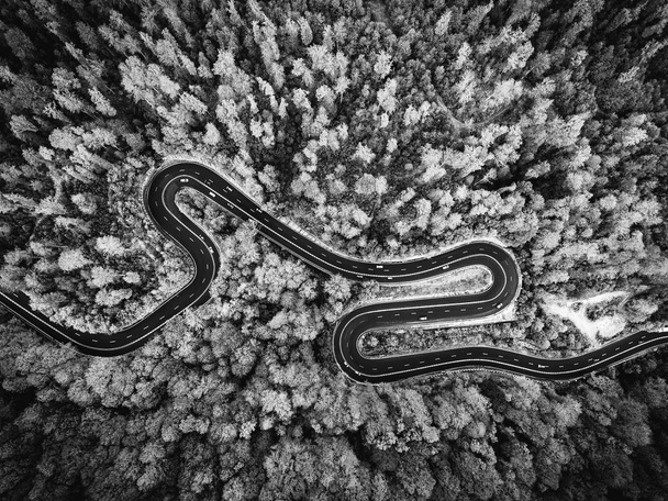 Luchtfoto drone zicht op een gebogen bochtige weg door het bos. B - Foto, afbeelding