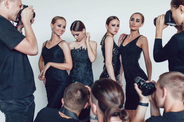 Photographers paparazzi take photos of women in cocktail dresses. - Valokuva, kuva