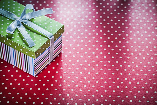 Decorated gift box on red tablecloth holidays concept - Фото, зображення