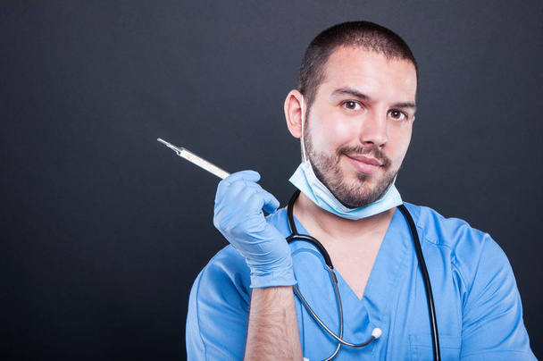 Doktor na sobě drhne drží teploměr - Fotografie, Obrázek