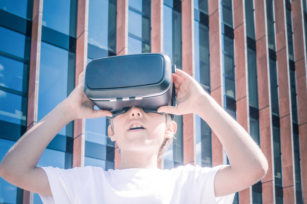 Niño con gafas de realidad virtual en la ciudad
 - Foto, Imagen