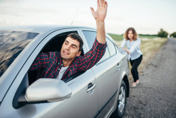 mężczyzna jadący i kobieta pchanie samochodu - Zdjęcie, obraz