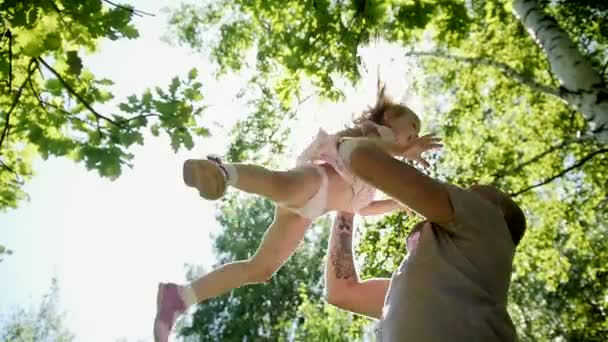 Father throwing up his little daughter in park, slow-motion - Footage, Video