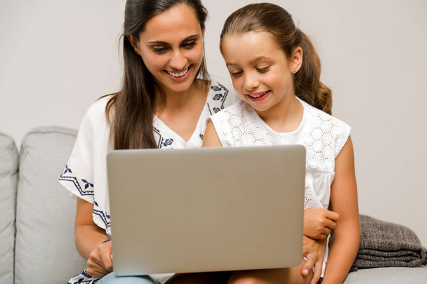 Mother and Daughter working with a a laptop  - Фото, изображение