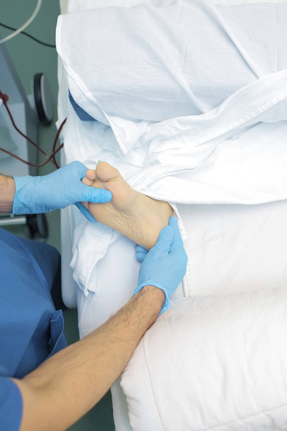 Doctor examines the patient's foot - Fotoğraf, Görsel