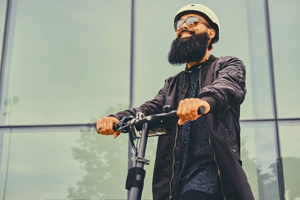 Elegante hombre barbudo en scooter eléctrico
 - Foto, imagen