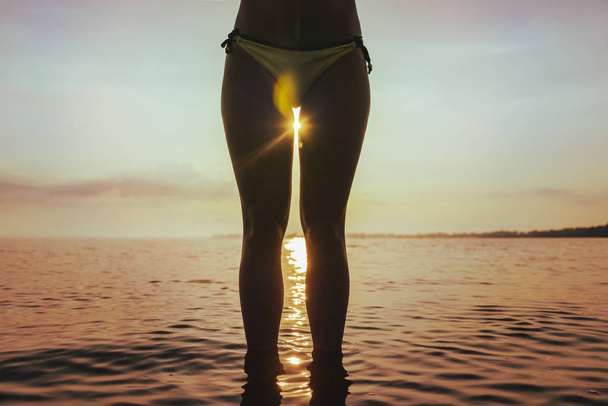 nascer do sol entre as pernas da mulher
 - Foto, Imagem